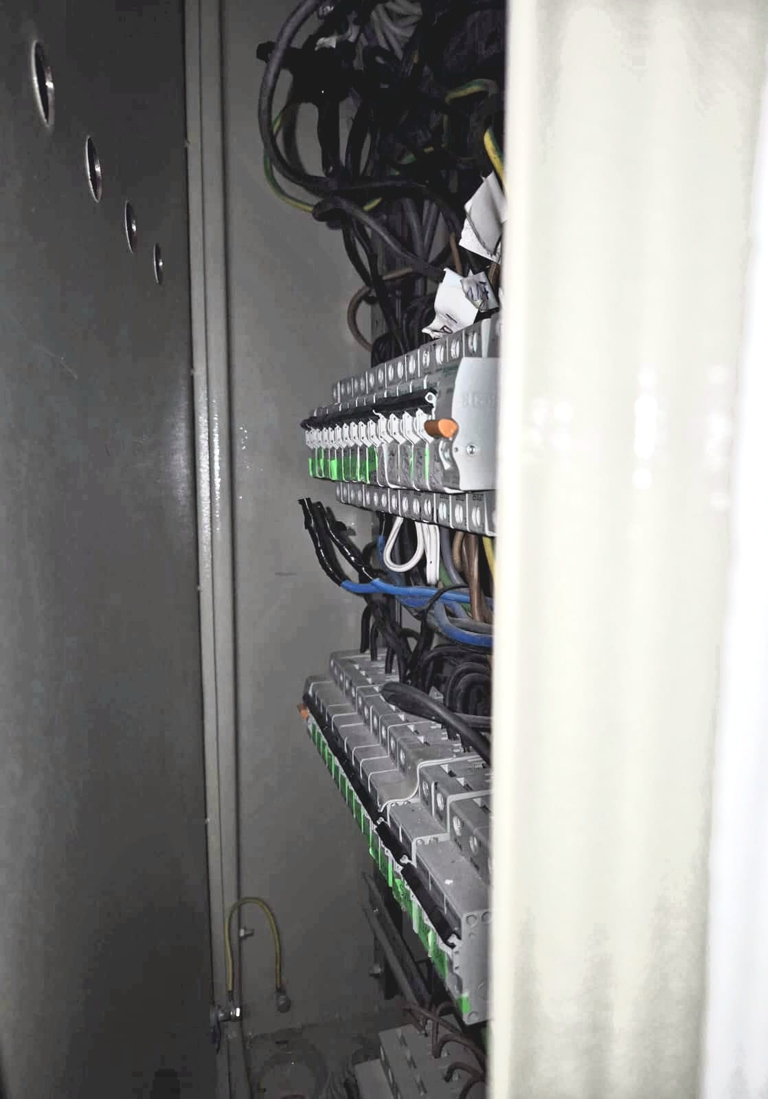 An open electrical box with circuit breakers on a hotel floor